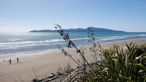Una playa con vista despejada al océano y montañas a lo lejos.