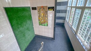 Een trap met een tapijtvloer, een bordje voor een lift en een muur met een decoratief paneel.