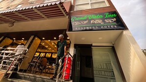 Een hotel voor zakenreizigers met een bord in verschillende talen, een trap naar de ingang en een uitzicht op de binnenaanwezige eetruimte.