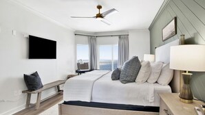 Un dormitorio con cama, mesita de noche, lámpara y ventilador de techo.