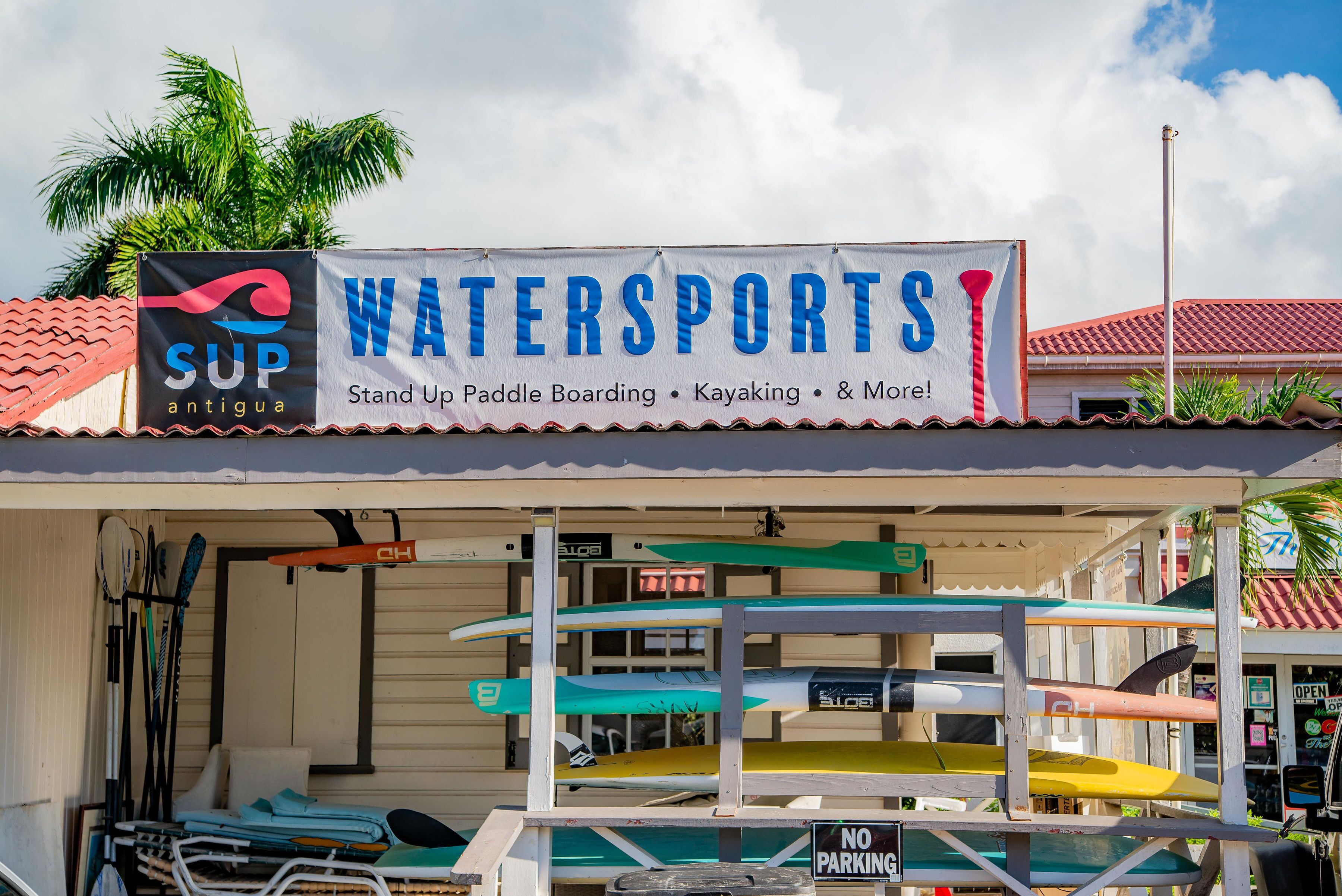 A watersports facility with a sign advertising stand-up paddle boarding, kayaking, and more.