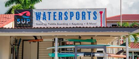 A watersports facility with a sign advertising stand-up paddle boarding, kayaking, and more.