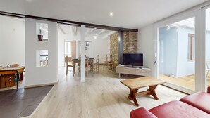 A modern living room with a wooden table, red sofa, and a TV. - Roesselmann 2bdrm 1 Parking (Colmar)