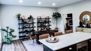 A modern kitchen with a central island, dark wooden shelving, and a large mirror. - Mid-Century Modern gem in the heart of the country, close to Lake Lanier.  (Auburn)