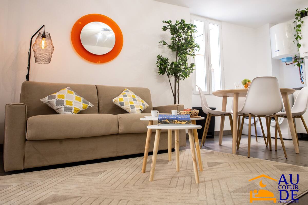 A modern living room with a sofa, a coffee table, and a dining area with chairs.