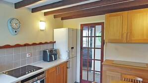 Una cocina con estufa, horno, refrigerador y cafetera.
