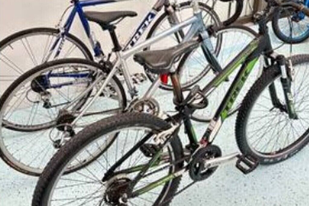 A bicycle rack with multiple bicycles parked.