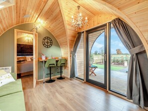 A cozy room with a wooden ceiling, a dining area with two chairs, a bed, and a large window with curtains. - 1 bedroom accommodation in Church Broughton, near Derby (Church Broughton, near Derby)