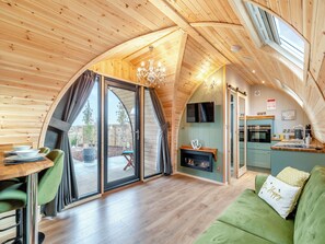 A cozy, wooden interior with a dining area, a fireplace, and a kitchen. - 1 bedroom accommodation in Church Broughton, near Derby (Church Broughton, near Derby)