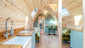 A cozy, wooden interior with a kitchen, dining area, and a living space.