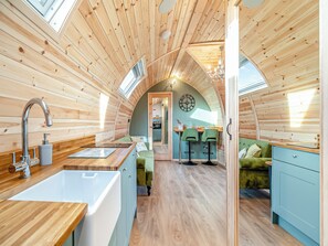 Un intérieur chaleureux et rustique, avec une cuisine, un coin repas et un espace de vie.