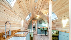 Un interno accogliente in legno con cucina, zona pranzo e soggiorno.