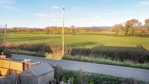 A rural landscape with a road, a wooden fence, and a clear sky. - 2 bedroom accommodation in Burtle, near Glastonbury (Burtle, near Glastonbury)