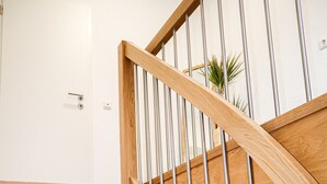 A wooden staircase with metal railings and a door at the top.