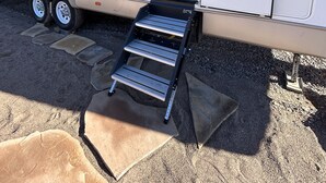 A recreational vehicle with a ramp leading to the entrance, a logo, and a window.