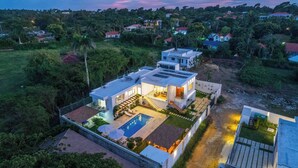 Una casa moderna con piscina, ventanas amplias y un jardín bien cuidado.