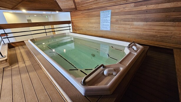 A wooden spa pool with a glass enclosure, wooden walls, and a caution sign. - Pet Friendly King Studio, Center Village, walk to slopes 446 (Copper Mountain)
