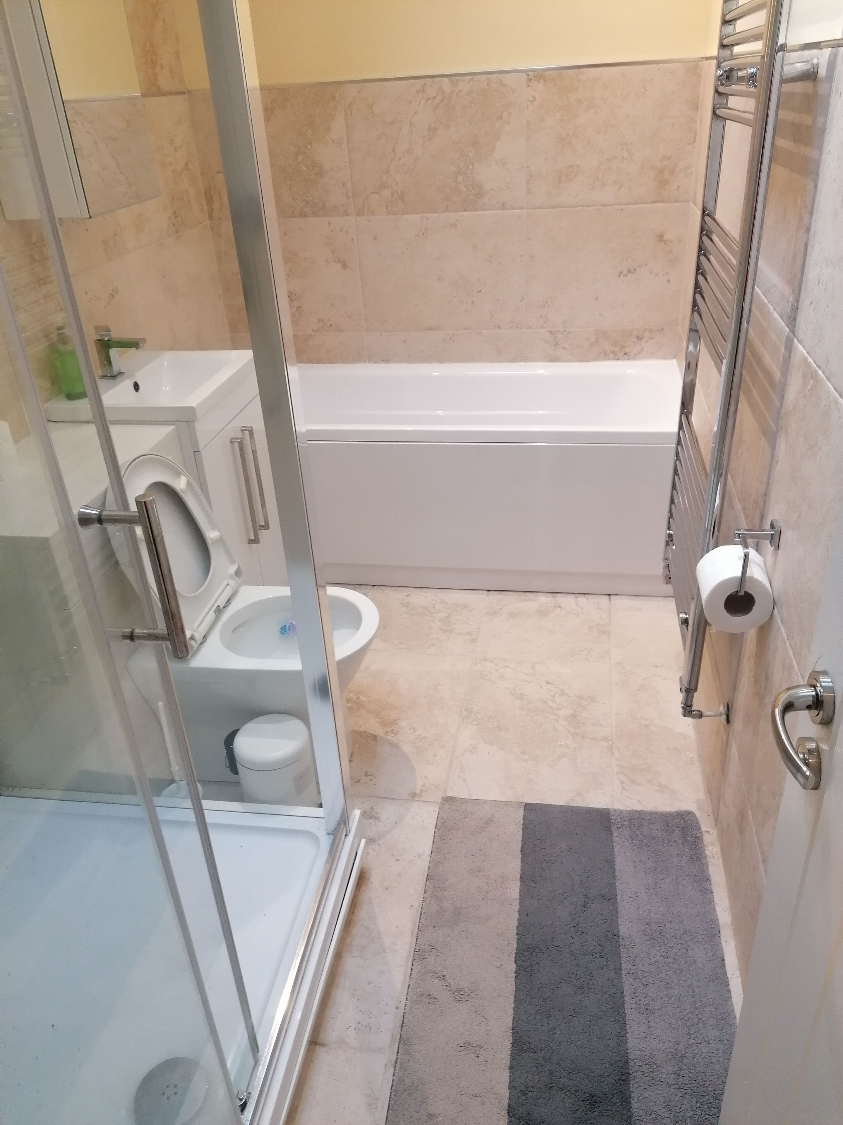 Une salle de bain avec une douche à parois de verre, une baignoire blanche, des toilettes et un lavabo.