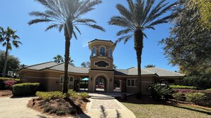 A two-story house with a central tower, surrounded by palm trees and a well-maintained garden. - Amazing Centrally Located Home in Peaceful Area (Jacksonville)