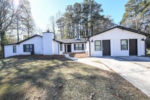 A two-story house with a front porch, a garage, and a driveway.