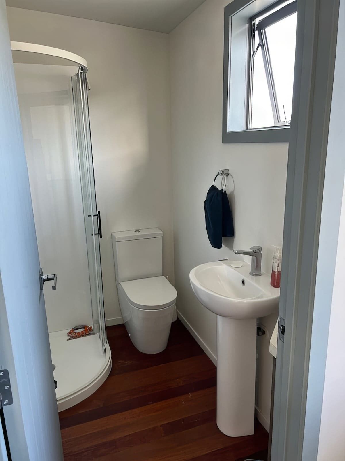 A bathroom with a toilet, a sink, and a glass shower enclosure.