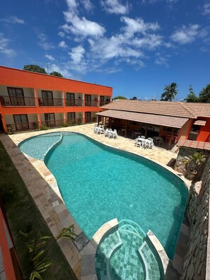 A hotel with a swimming pool, outdoor seating, and a multi-story building. - Pousada Deu Praia Maragogi (Maragogi)