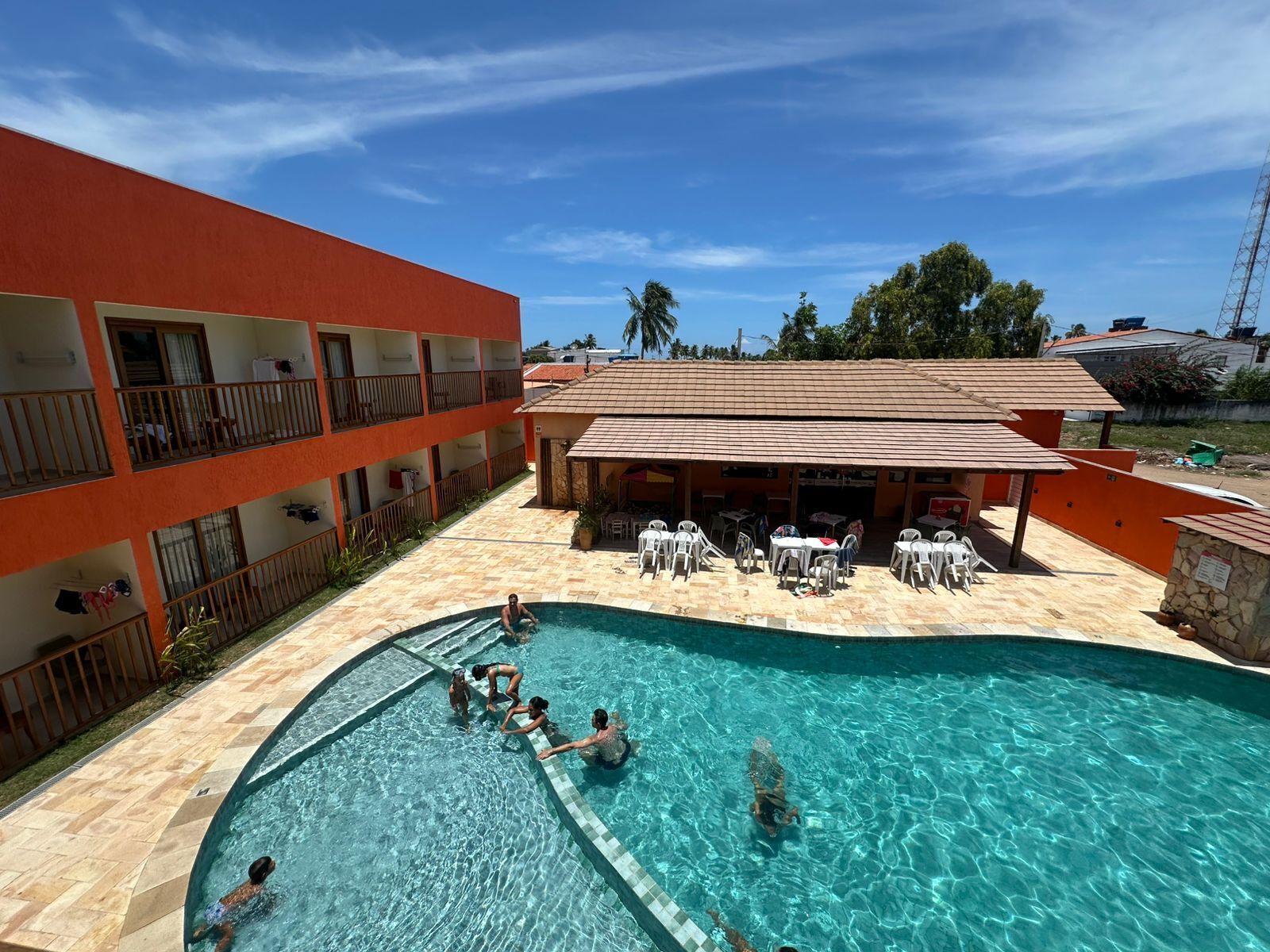 Un hotel con piscina, area relax all'aperto e un edificio a più piani.