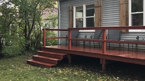 Ein Haus mit einer Veranda, Stufen und einem Geländer.