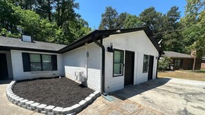 Ein eingeschossiges Haus mit Vorgarten, Auffahrt und kleinem Garten.