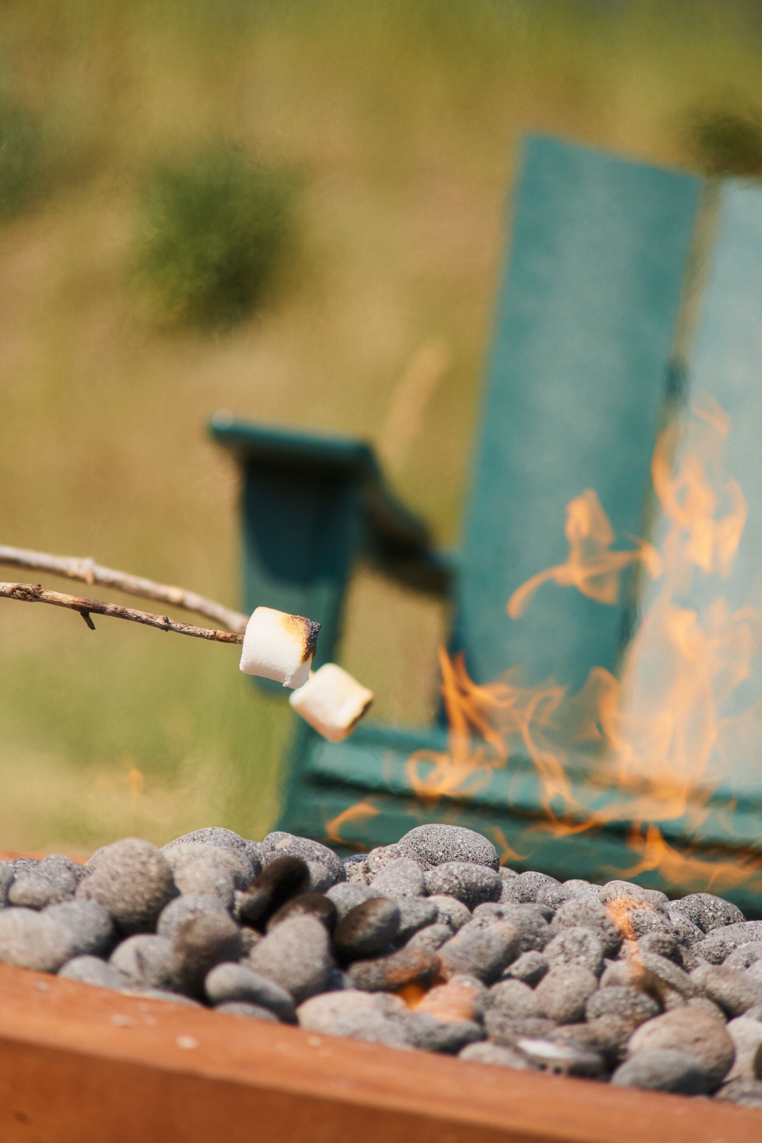 A close-up of a marshmallow being roasted over charcoal.