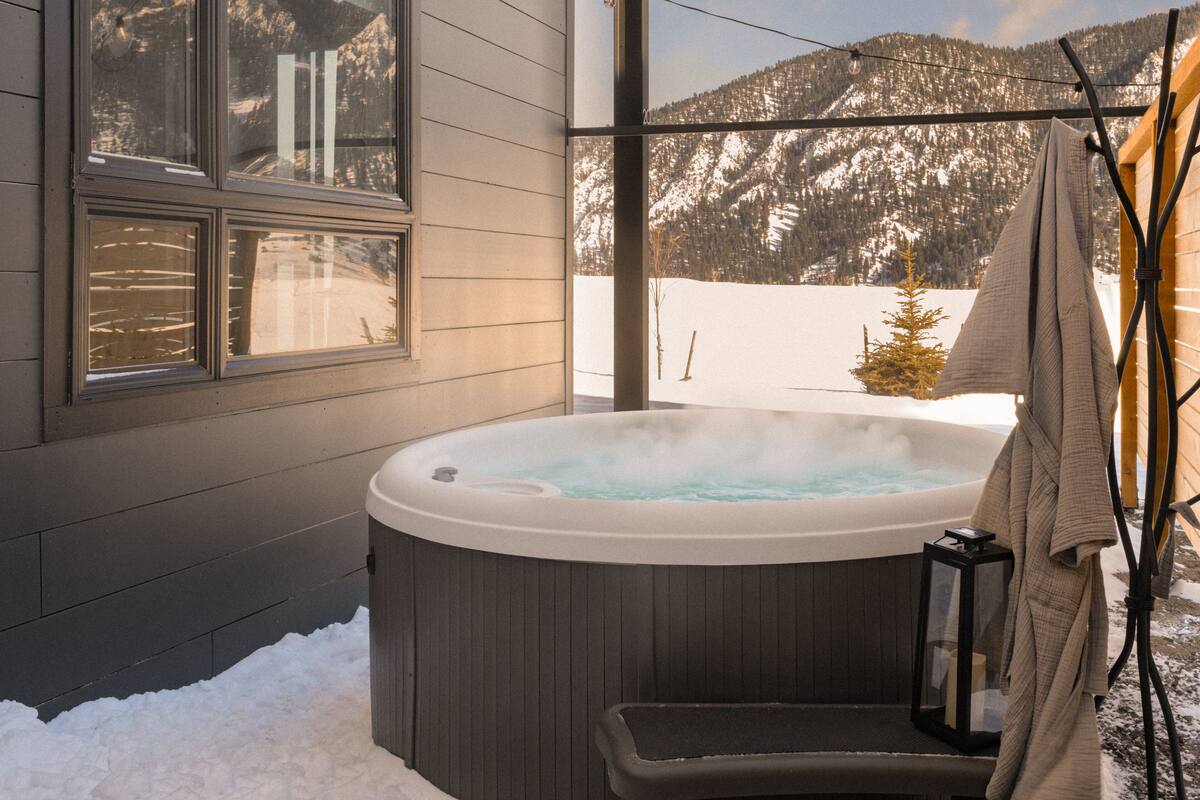 Un jacuzzi al aire libre con vista a una montaña nevada.