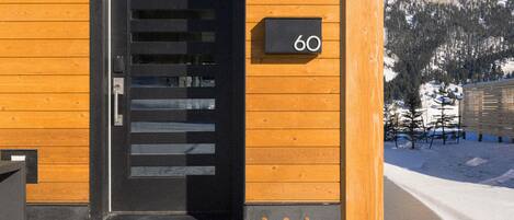 A wooden building with a black door and a number '60' sign.
