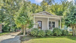 A small, single-story house with a front porch, surrounded by trees and a well-maintained lawn. - Fun & Funky #2 centrally located in Memphis! (Memphis)