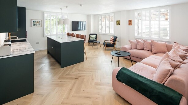 A modern living space with a kitchen island, a sofa, and a dining area. - 2Bed 2Bath Stunning Shoreditch Apartment (London)