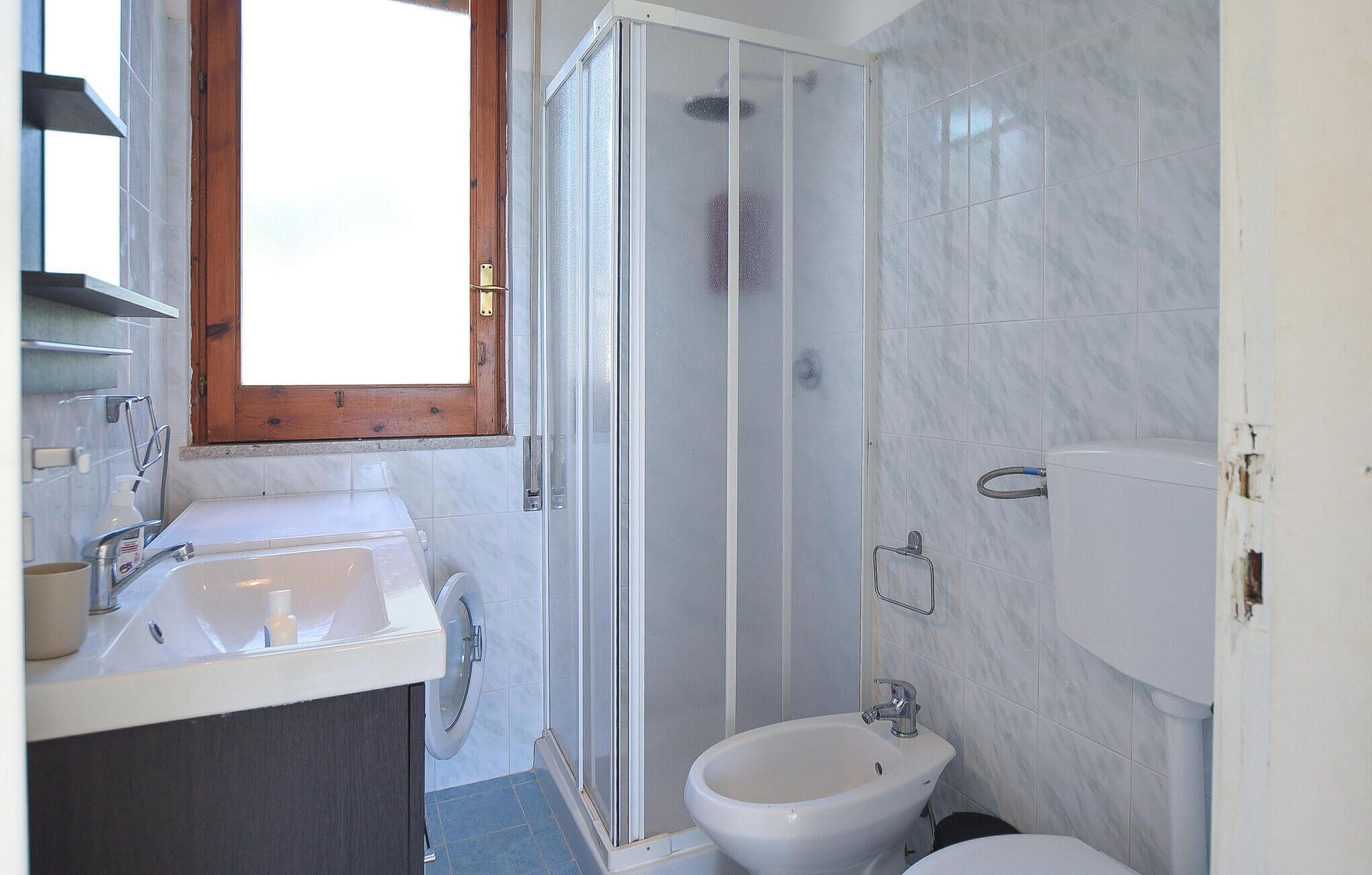 A bathroom with a shower, toilet, and sink.