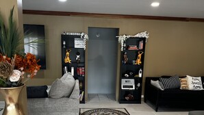 A modern living room with a grey sofa, a black armchair, and a coffee table. There is a decorative rug and a vase with flowers on the floor. - Bay Bliss Retreat home in Ironshore, Montego Bay, less than 10 mins to airport. (Montego Bay)