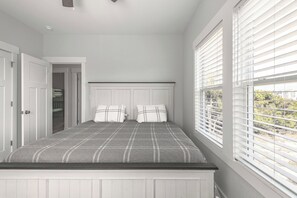 A bedroom with a bed, white walls, a window with blinds, and a door leading to a closet. - Sandy Adventures!
Third row from the ocean!
Wild Horses roam the area- Carova (Corolla)