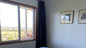 Una camera da letto con un letto grande, una finestra vista paesaggio e due quadri appesi al muro.
