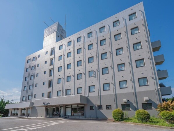A multi-story hotel with a modern design, featuring a prominent entrance with glass doors and a sign above. - Tabino Hotel EXpress Narita (Narita)