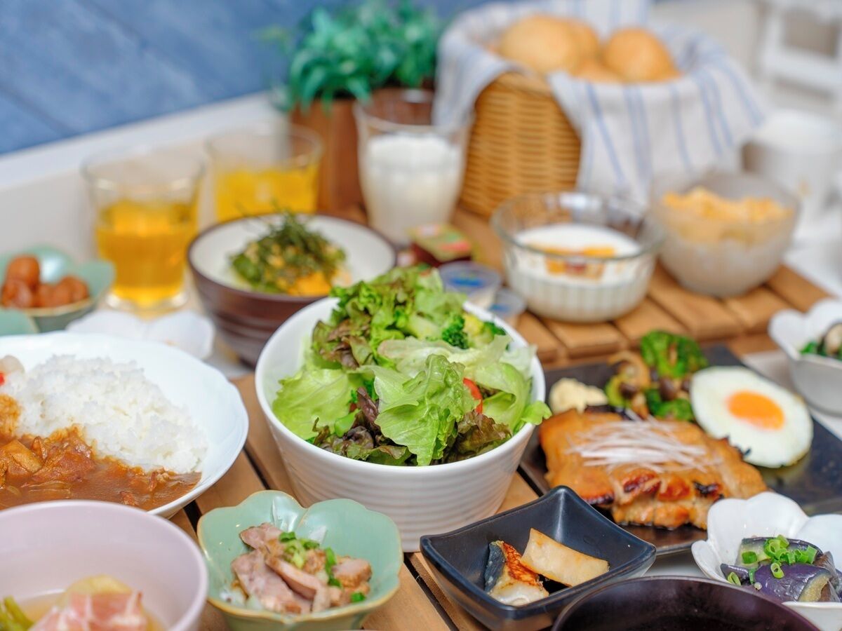 Variedad de platos, incluyendo arroz, ensalada y huevos, sobre una mesa.