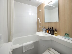 A modern bathroom with a white sink, a mirror, and three bottles of toiletries. - Tabino Hotel EXpress Narita (Narita)