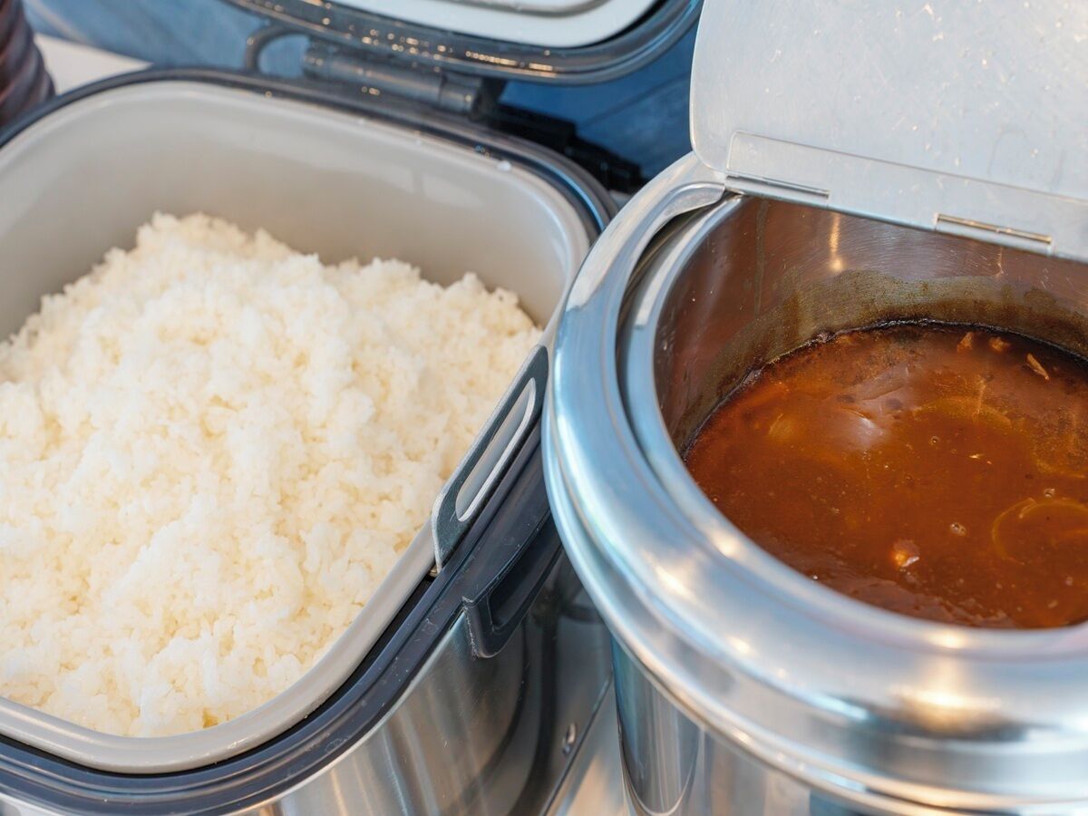 A food container with rice and a soup pot.