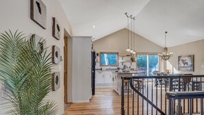 A spacious kitchen with white cabinets, a wooden island, and pendant lighting. - Cascadia (Cascade)