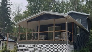 A single-story house with a covered porch, a small deck, and a fenced yard. - 4 Season Cabin great for Summer or Winter activities! 
Excellent Green Space (Marean Lake)