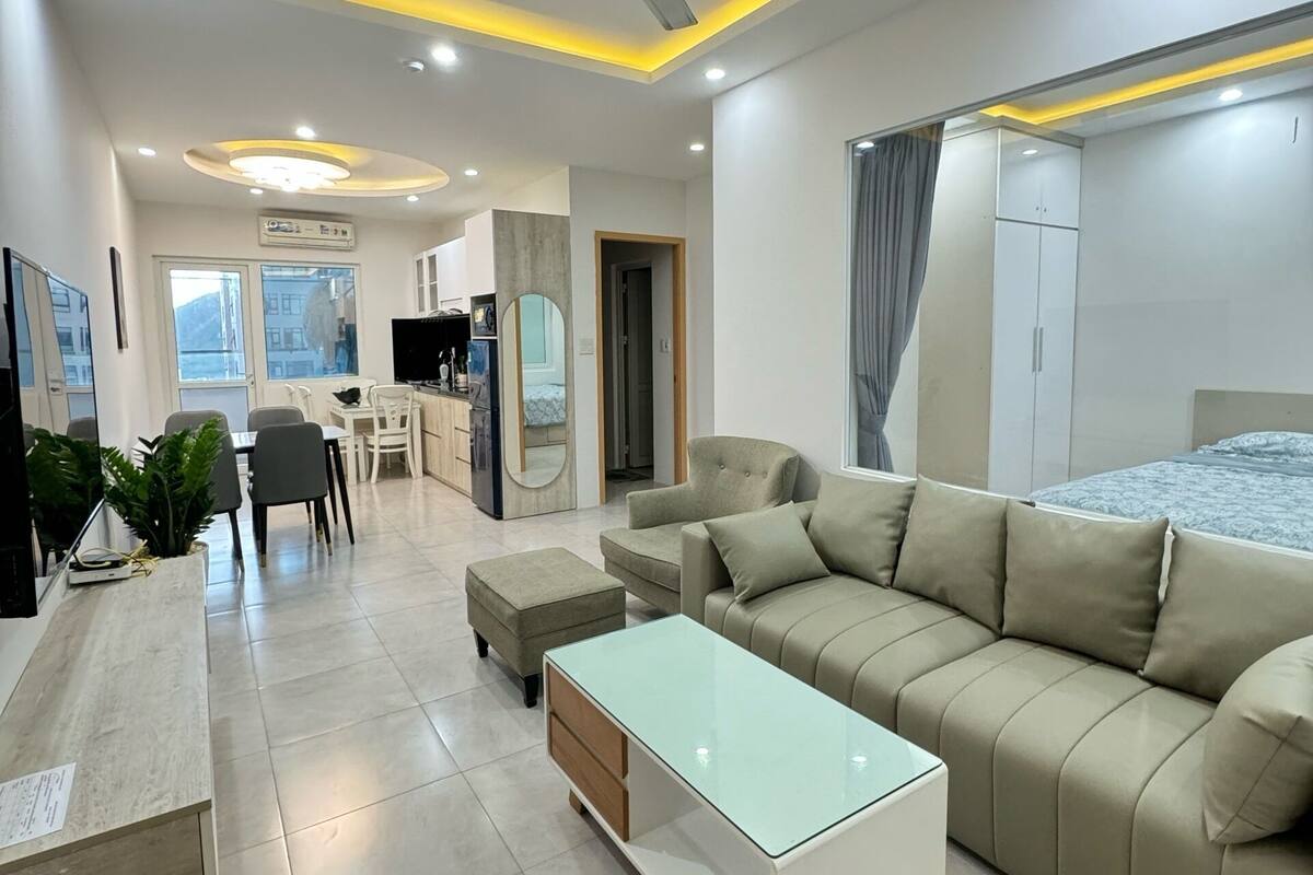 A modern living room with a sofa, coffee table, and dining area.