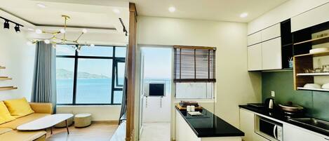A modern apartment with a kitchen, dining area, and living room.