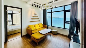 Una sala de estar moderna con un sofá, una mesita y vistas al mar a través de amplios ventanales.
