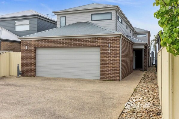 A two-story residential building with a garage, brick exterior, and a driveway. - Absolute waterfront modern 4 bedroom property in Woodlands area of Yarrawonga (Yarrawonga)
