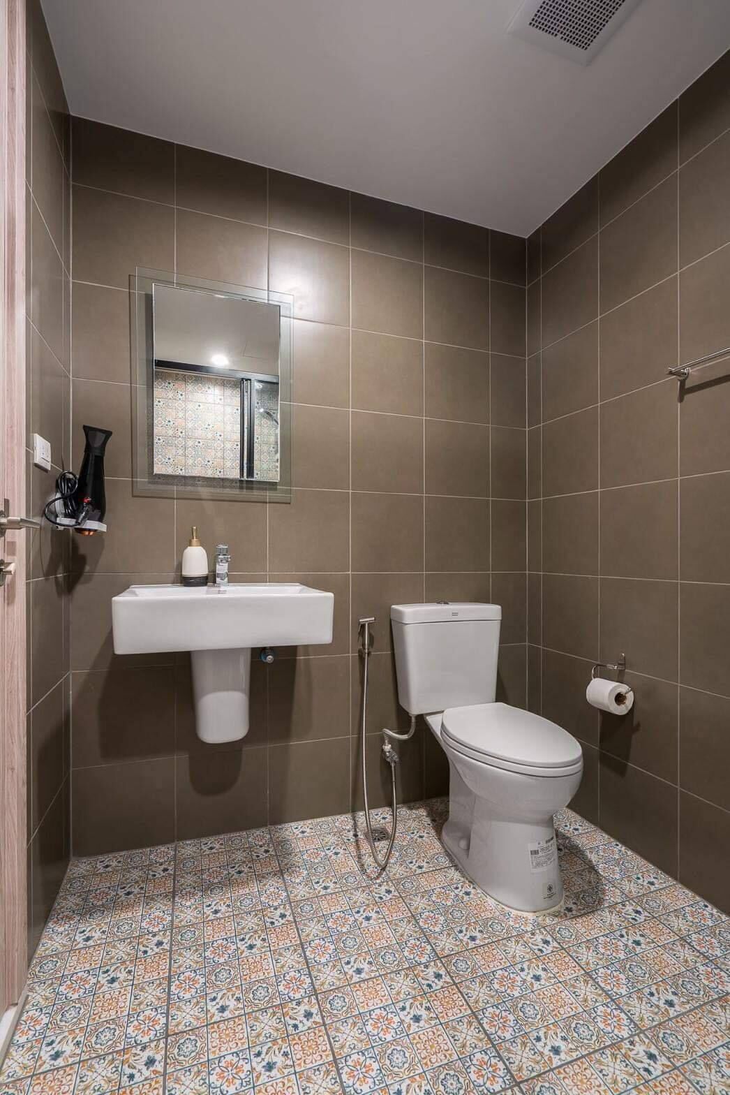 A bathroom with a toilet, sink, and shower.