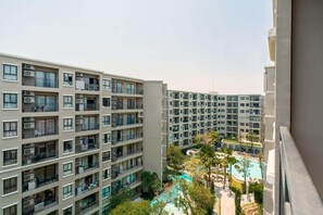 A multi-story hotel with balconies, a swimming pool, and a landscaped courtyard. - Lacasita Huahin Near beach  (Hua Hin)
